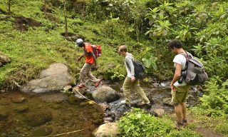 Manase, SENE guide, and SENE clients walk on the Kilimanjaro foothills